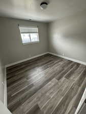 Empty room with dark hardwood / wood-style flooring