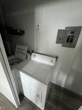 Clothes washing area with dark hardwood / wood-style floors and separate washer and dryer