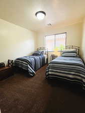 Carpeted bedroom with a textured ceiling