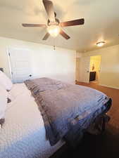 Carpeted bedroom featuring a textured ceiling and ceiling fan