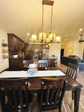 Dining room featuring ceiling fan, sink, light tile patterned floors, and vaulted ceiling