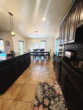 Kitchen featuring a wealth of natural light, pendant lighting, vaulted ceiling, and black dishwasher