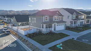 View of front of property with a mountain view, a garage, and a front yard