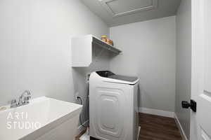 Clothes washing area featuring washer / dryer, sink, and dark wood-type flooring