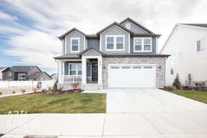 Craftsman inspired home with a front lawn, covered porch, and a garage