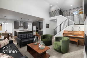 Carpeted living room featuring a chandelier, a towering ceiling, and sink