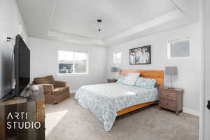 Primary bedroom featuring a tray ceiling