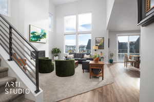 Living room featuring wood-type flooring and a towering ceiling