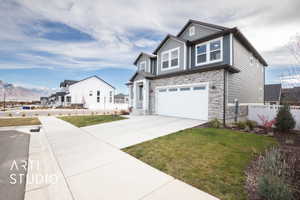 View of front of house with a mountain view, a garage, and a front yard