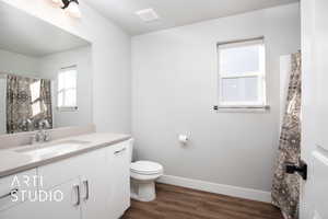Bathroom featuring hardwood / wood-style floors, vanity, and toilet