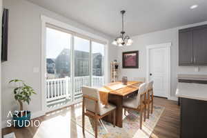 Dining area with light hardwood / wood-style floors and a notable chandelier