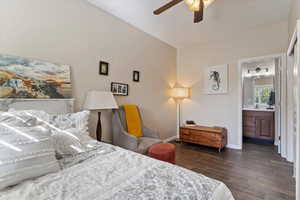 Bedroom with ensuite bathroom, vaulted ceiling, ceiling fan, dark wood-type flooring, and sink