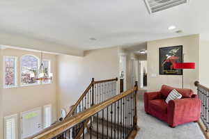 Corridor featuring carpet floors and an inviting chandelier