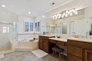 Bathroom featuring vanity and independent shower and bath