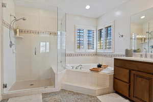 Bathroom featuring separate shower and tub and vanity