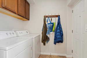 Laundry room featuring cabinets, independent washer and dryer, and light tile patterned floors