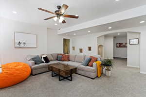 Living room featuring ceiling fan and light carpet