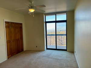 Unfurnished bedroom featuring access to exterior, ceiling fan, light colored carpet, and a closet