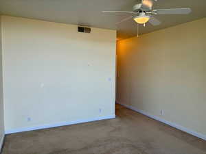 Empty room featuring ceiling fan and light colored carpet