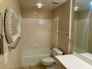 Full bathroom with tile patterned floors, vanity, toilet, and tiled shower / bath