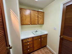 Interior space featuring dark tile patterned flooring and sink