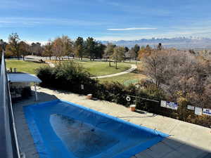 View of swimming pool with a mountain view and a yard