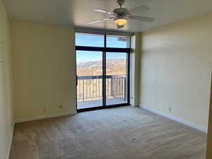 Spare room featuring a mountain view, ceiling fan, and light colored carpet