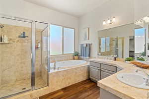 Bathroom featuring vanity, separate shower and tub, and wood-type flooring