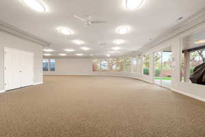 Carpeted spare room with a textured ceiling and ceiling fan