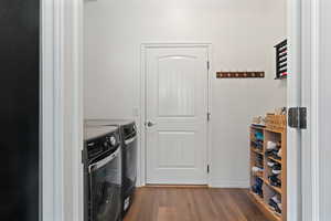 Laundry room with washing machine and dryer and wood-type flooring