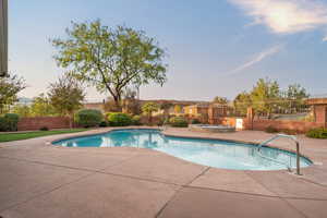 View of pool with an in ground hot tub and a patio