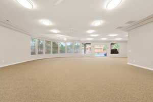 Empty room featuring carpet flooring, a textured ceiling, and ceiling fan