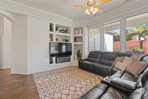 Living room featuring hardwood / wood-style flooring, ceiling fan, and ornamental molding