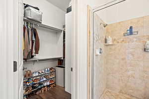 Bathroom featuring wood-type flooring and a shower with shower door