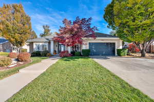 View of front of property with a garage and a front lawn