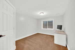 Unfurnished bedroom featuring carpet and a textured ceiling