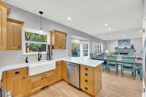 Kitchen with sink, dishwasher, tasteful backsplash, kitchen peninsula, and light wood-type flooring