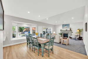 Dining area with lofted ceiling and light wood-type flooring