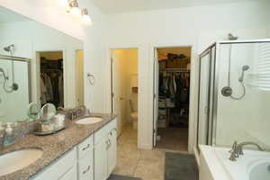 Full bathroom with vanity, tile patterned flooring, plus walk in shower, and toilet