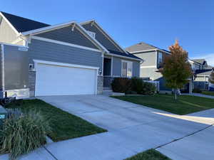 View of front facade featuring a front lawn and a garage