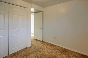 Unfurnished bedroom featuring carpet flooring and a closet