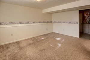 Carpeted spare room with a textured ceiling