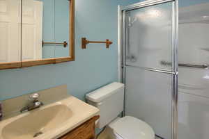 Bathroom with toilet, vanity, and walk in shower