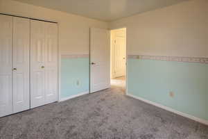 Unfurnished bedroom featuring a closet and carpet