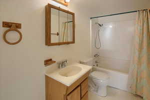 Full bathroom with shower / bath combination with curtain, toilet, and vanity