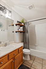 Full bathroom featuring tile patterned floors, vanity, shower / bath combo, and toilet