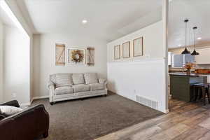 Living room with hardwood / wood-style floors and lofted ceiling