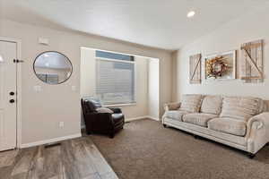 Living room with hardwood / wood-style floors and vaulted ceiling