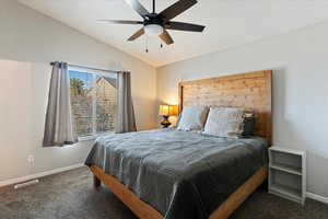 Carpeted bedroom with vaulted ceiling and ceiling fan