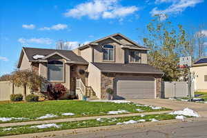 View of front of home with a front yard and a garage